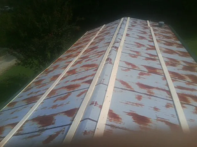 Rusted metal roof panels with new wood purlins before replacement — Storm Damage Roof Repair in Glasford by Roofing Brothers