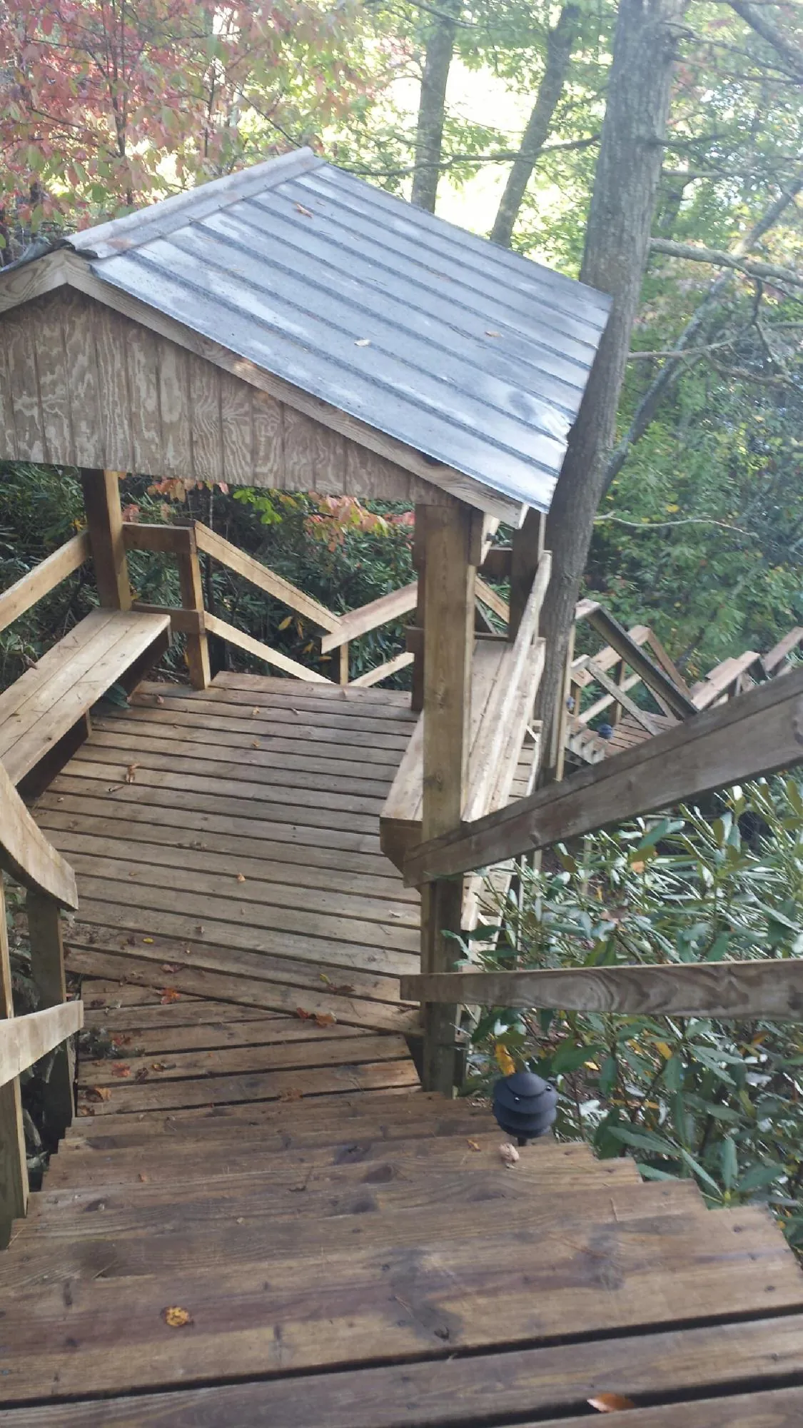 Metal roofed shelter over wooden steps on a wooded walkway — Skylight Repair & Installation work by our crew in Glasford